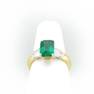 This 18 karat yellow gold and platinum ring has a 1.52 carat fine emerald as well as four tapered baguette diamonds with 0.68 total karat weight and F/VS rating. 